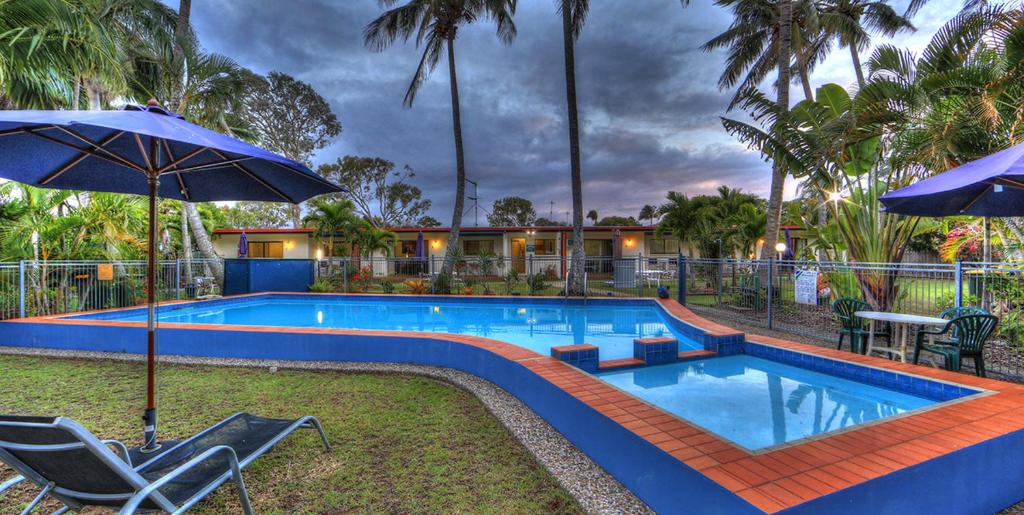 An outdoor swimming pool and small wading pool with bright blue sides and terra-cotta trim.
